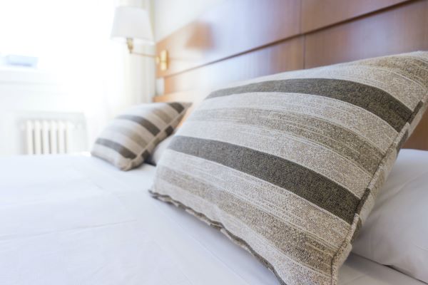 A hotel bed with striped pillows