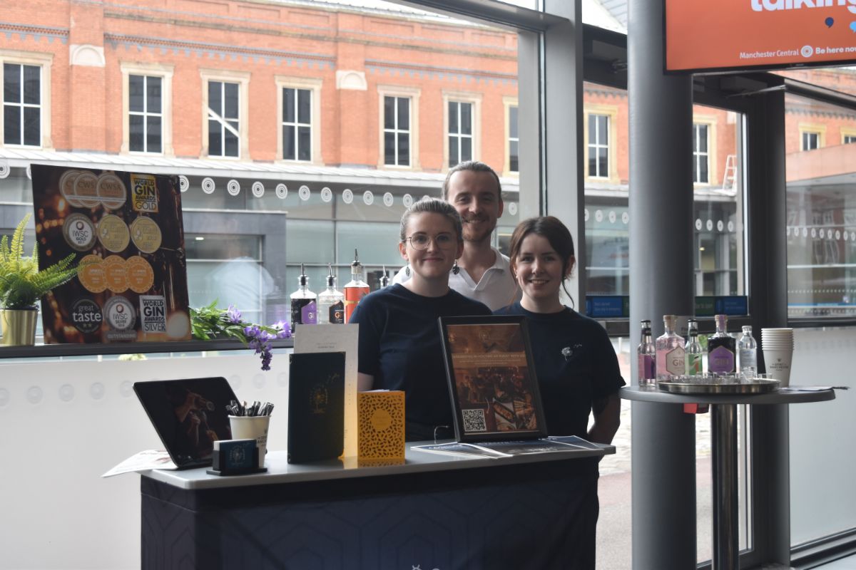 3 member of staff standing behind the reception
