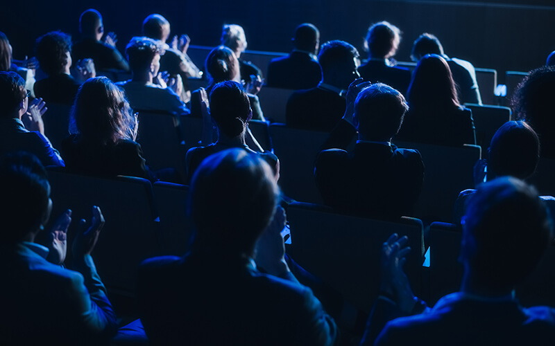 Crowd of Smart Tech People Applauding in Dark Conference Hall During a Motivational Keynote Presentation. Business Technology
