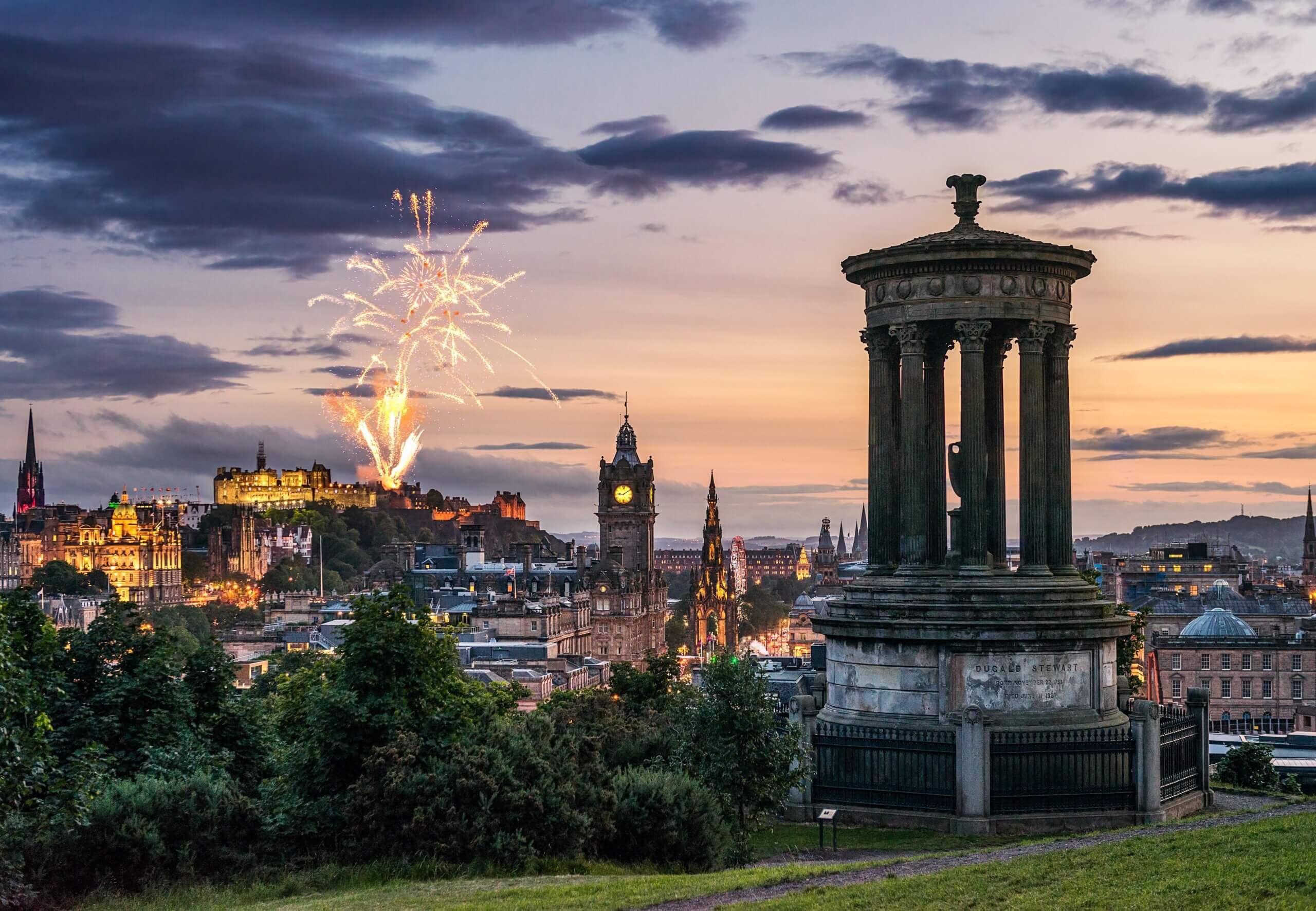 Fireworks at dusk in the sky over city monuments