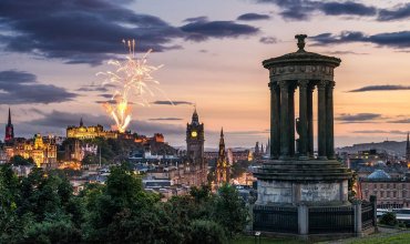 Fireworks at dusk in the sky over city monuments