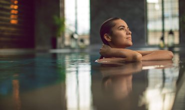Beautiful young woman relaxing on indoors poolside