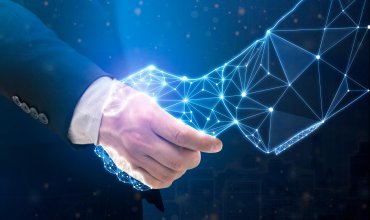 Businessperson shaking hand with digital partner over