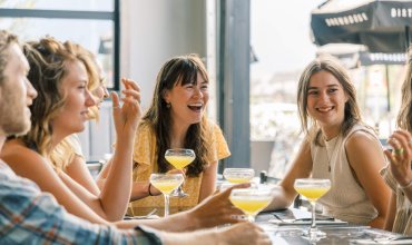 Group of friends enjoy drinks at cocktail bar / Brewery