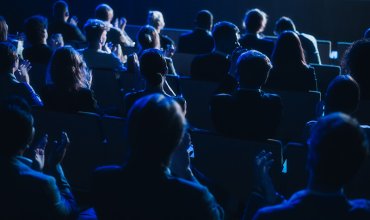 Crowd of Smart Tech People Applauding in Dark Conference Hall During a Motivational Keynote Presentation. Business Technology