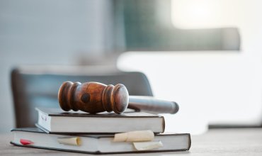 Justice, gavel and law books on table in office for court trial, legislation or fair constitution by judicial system. Firm, closeup and legal hammer by information for corporate case in workplace.