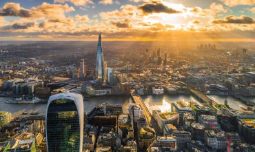Aerial view depicting sunbeams falling down on The Shard building and surrounding architecture - including London Bridge and 20 Fenchurch Street (the Walkie-Talkie building) in central London, UK.