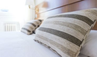 A hotel bed with striped pillows
